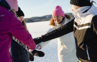 Naiset ulkoilevat jäällä ja laittavat kädet yhteen yhteisen hengen merkiksi.