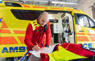 Ambulanssi ja varusteita huoltava pelastusalan ammattilainen. Kuva: Johanna Sell