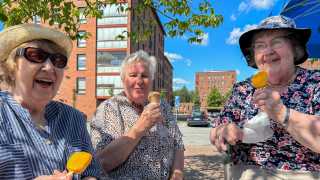 Kolme naista kesällä ulkona syömässä jäätelöä